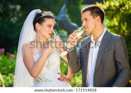 Just married couple drinking champagne outdoors