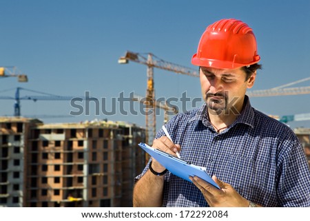 Construction site worker looking at paper,controls quality of the construction