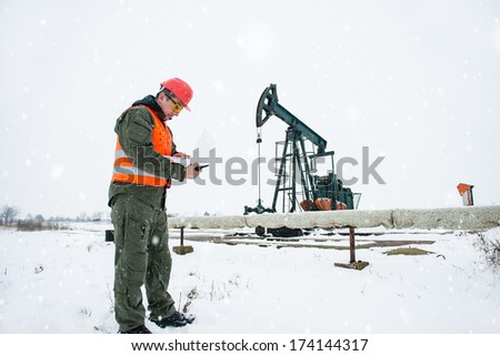 Oil Drill, field pump jack with snow storm and worker. See more images and video from this series and Refinery series.