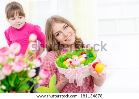 Family celebrating Easter holiday with a full basket of colorful Easter eggs