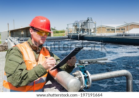 An engineer controlling the quality of water , aerated activated sludge tank at a waste water treatment plant