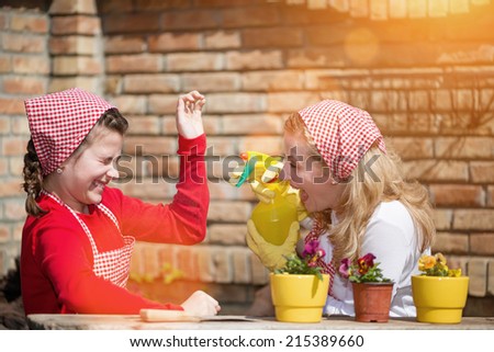Mother and daughter gardening flowers in the back yard, laughing together.Flare light