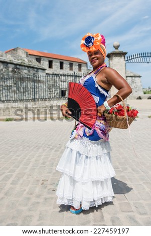 Attractive woman in traditional Cuban clothing posing at the street of Havana