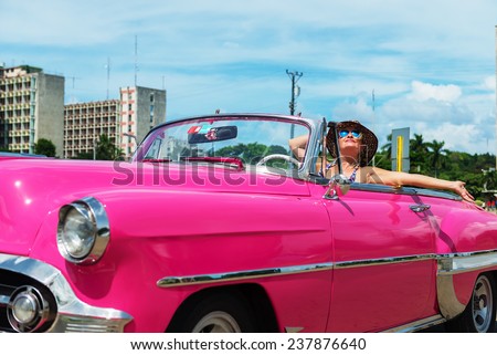 Caucasian, happy woman with arms outstretched in the pink cabriolet, convertible car