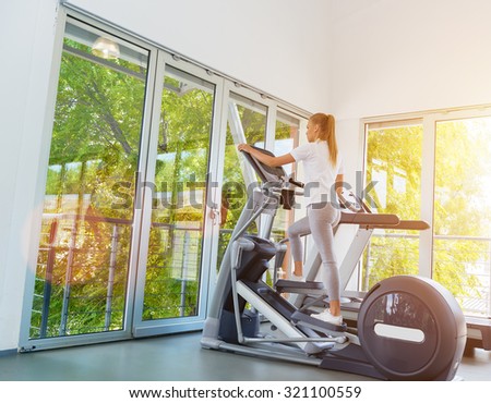 Young, beautiful woman on the cross training in the gym.Fitness training.Lens flare