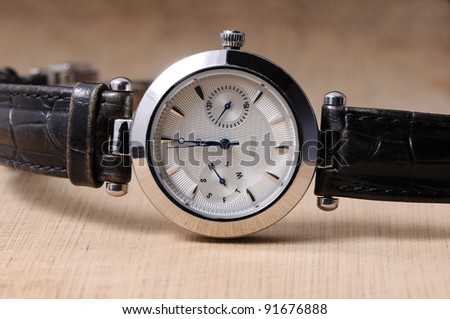 closeup of the  luxurious lady\'s  watch on the wooden texture