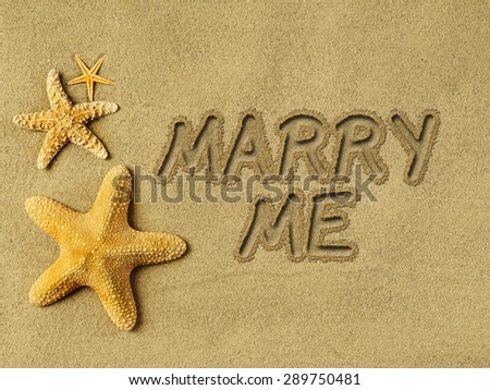 Marry me text on sand