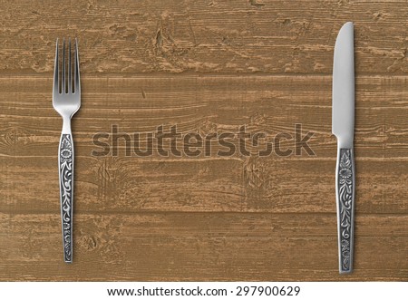 Table knife and fork on wood