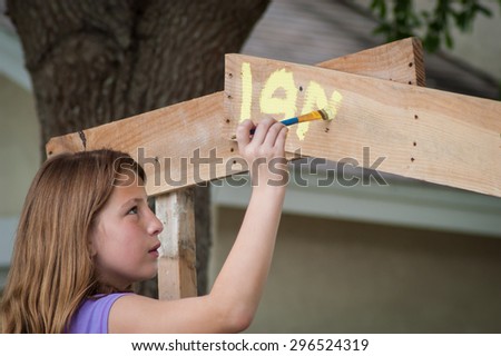 Head and Shoulders of a young girl painting a lemonade stand