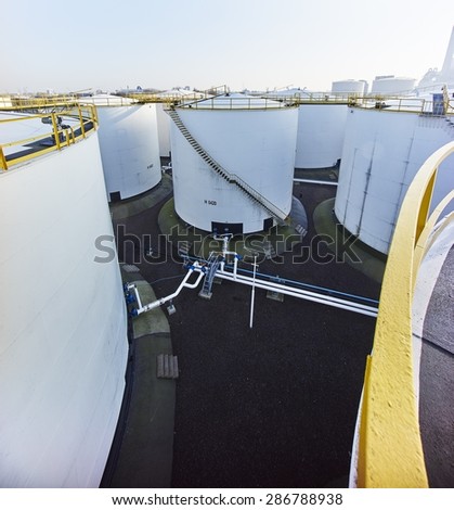 large white fuel containers against blue sky