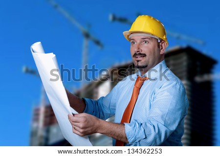 Man consults a project. In Background building in construction.
