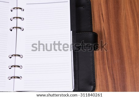Black notebook on wooden background
