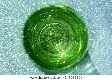 Abstract image of the inside of a green glass bottle with a sparkling blue background