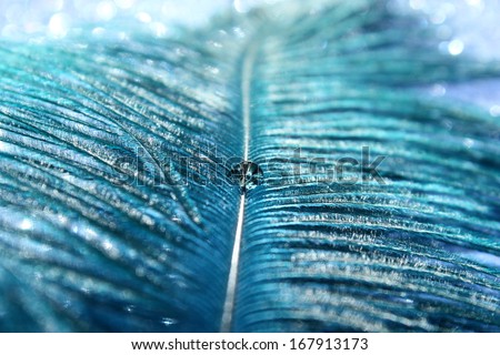 An abstract image of a vibrant blue feather with a sparkling water drop