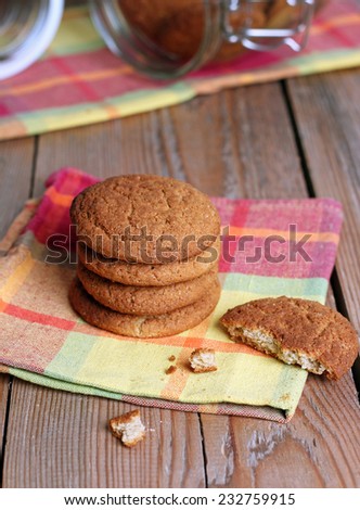 Fresh oatmeal cookies in a pile with broken cookie on a napkin