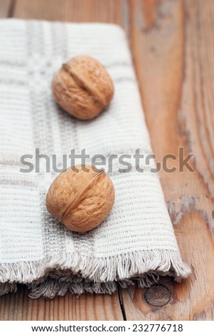 Walnuts and napkin on a wooden table. Russian tradition to eat nuts on Christmas holidays. Selective focus