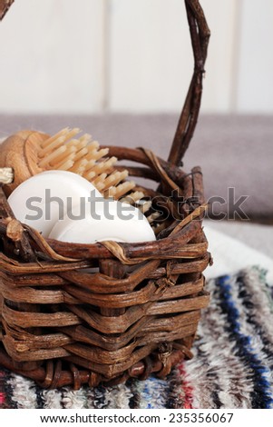 Spa essentials in a basket including olive and honey soaps, towels, wash cloths, brush. Selective focus