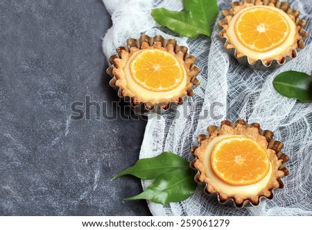 Hand made tart, tartlet with lemon curd on a black chalkboard. Selective focus, top view, copy space background