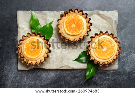 Hand made tart, tartlet with lemon curd on a black background. Selective focus, top view
