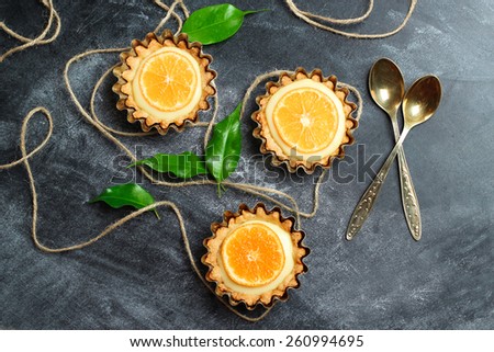 Hand made tart, tartlet with lemon curd on a black background. Selective focus, top view