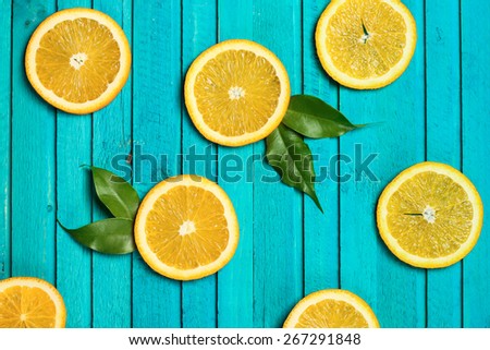 Slices of oranges on a turquoise  wooden background. Selective focus, top view
