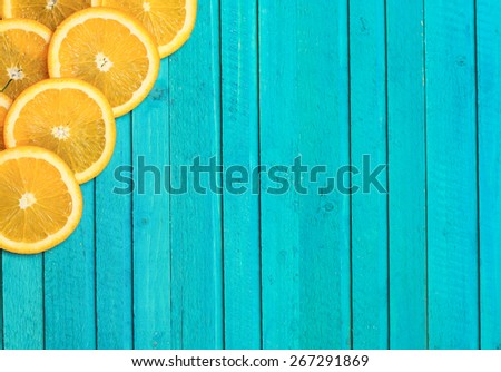 Slices of oranges on a turquoise  wooden background. Selective focus, copy space background, top view