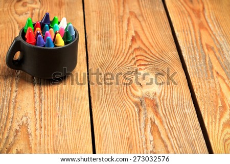 Still life, business, education concept. Crayons in a mug on a wooden table. Selective focus, copy space background
