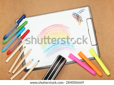 Still life, children, school, education concept. Drawing rainbow with stationery, clips, stapler,  pens, markers and pencils on a table. Selective focus, copy space background, top view