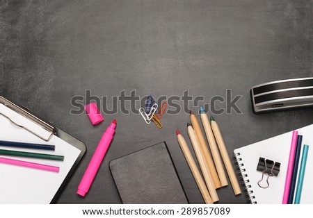 Still life, business, education concept. Office supplies, notepad, diary, marker, stapler, clips and pencils on a chalkboard. Selective focus, copy space background, top view
