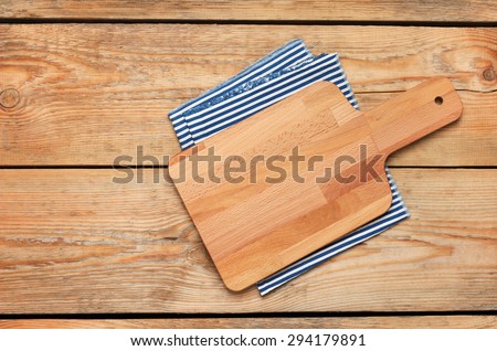Still life, food and drink concept. Kitchen cooking utensils (cutting board, napkin) on a wooden table. Selective focus, copy space background, top view