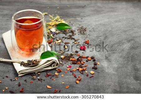 Still life, food and drink concept. Various kinds of tea with a glass of tea on a black chalkboard. Selective focus, copy space background.