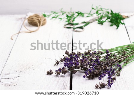 Still life, food and drink, health concept. Mix of fresh herbs on a wooden table, lavender, savory, thyme, scissors and rope. Selective focus, copy space white background
