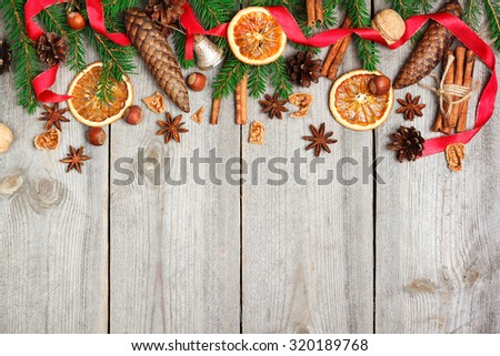 Still life, food and drink, seasonal and holidays concept. Christmas decoration with fir tree, oranges, cones, nuts, spices on a wooden table. Selective focus, copy space background, top view