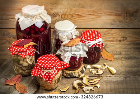 Still life, food and drink, seasonal concept. Autumn preserved fruits, vegetables and mushrooms on a rustic wooden table. Selective focus, copy space background