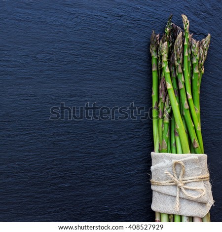 Healthy concept. Bunch of organic fresh asparagus on a grunge stone table. Selective focus, copy space background, flat lay