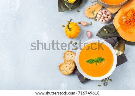 Food and drink, still life, diet and nutrition concept. Seasonal fall autumn roasted orange pumpkin carrot soup with ingredients on a table. Copy space cozy background, top view flat lay