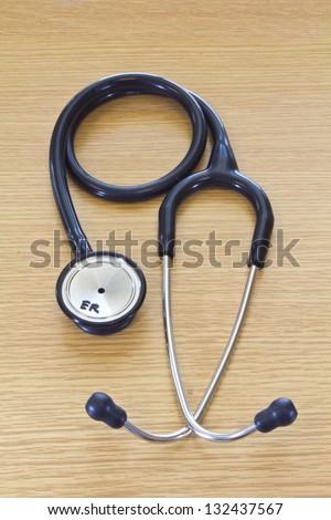 Photo of a dual head high quality stethoscope used for medical examinations in the healthcare and fitness industries isolated on a white wood floor.