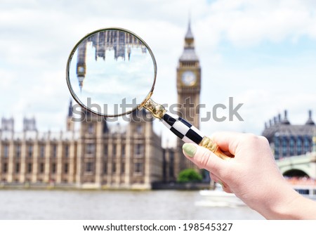 Magnifying glass in the hand against Big Ben in London