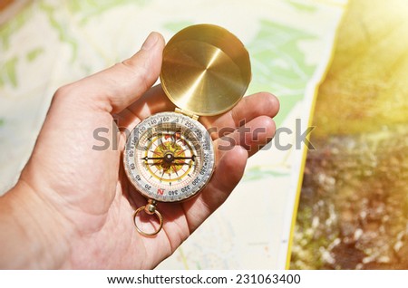 Vintage compass in the hand against a map