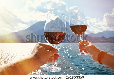 Two wineglasses in the hands. Varenna town at the lake Como, Italy