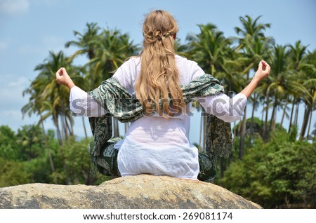 Young woman meditating on Agonda beach. Goa, India