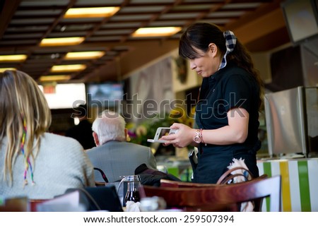 waitress in restaurant taking customer orders