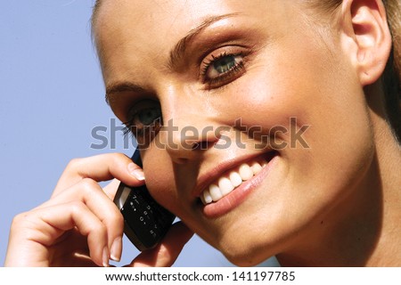 Beautiful woman talking on cell phone while looking at copyspace