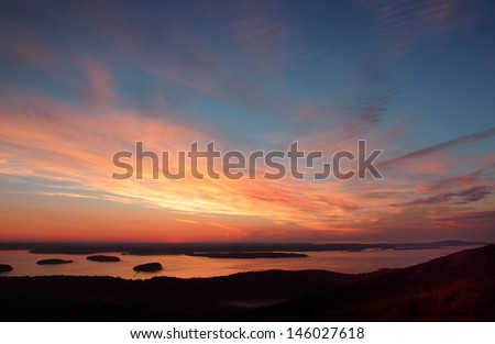 A dramatic muliticolored sunrise from the top of Cadillac Mountain on Mount Desert Island Maine