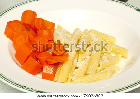 A white bowl with buttered carrots and penne pasta covered with olive oil and grated cheese for dinner.