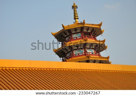 The top of Qibao Temple Pagoda as seen past the roof line located in Shanghai China.