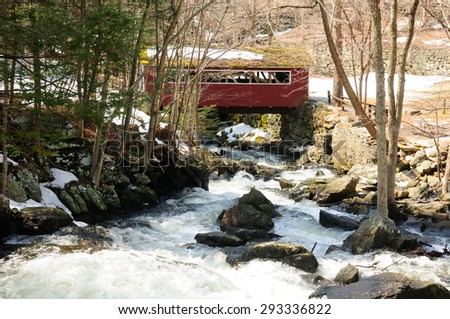 A red covered bridge at Southford Falls in Oxford Connecticut in early spring.