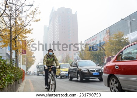 SHENYANG, CHINA - OCTOBER 31, 2014: People wearing masks in a heavy hazy weather morning. Located in Sanhao Street, Shenyang City, Liaoning Province, China.