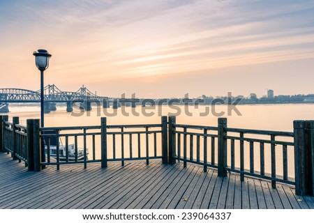 Yalu River Scenic Areas at morning. In the distance is Yalu River Bridge and North Korea. Located in Dandong City, Liaoning province, China.