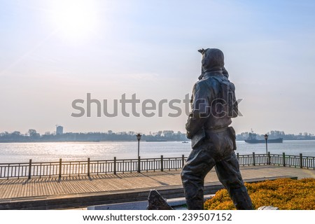 Dandong, China - November 8, 2014: Statue. A man look into the distance. In the distance is Yalu River and North Korea. Located in Yalu River Scenice Areas of Dandong City, Liaoning province, China.